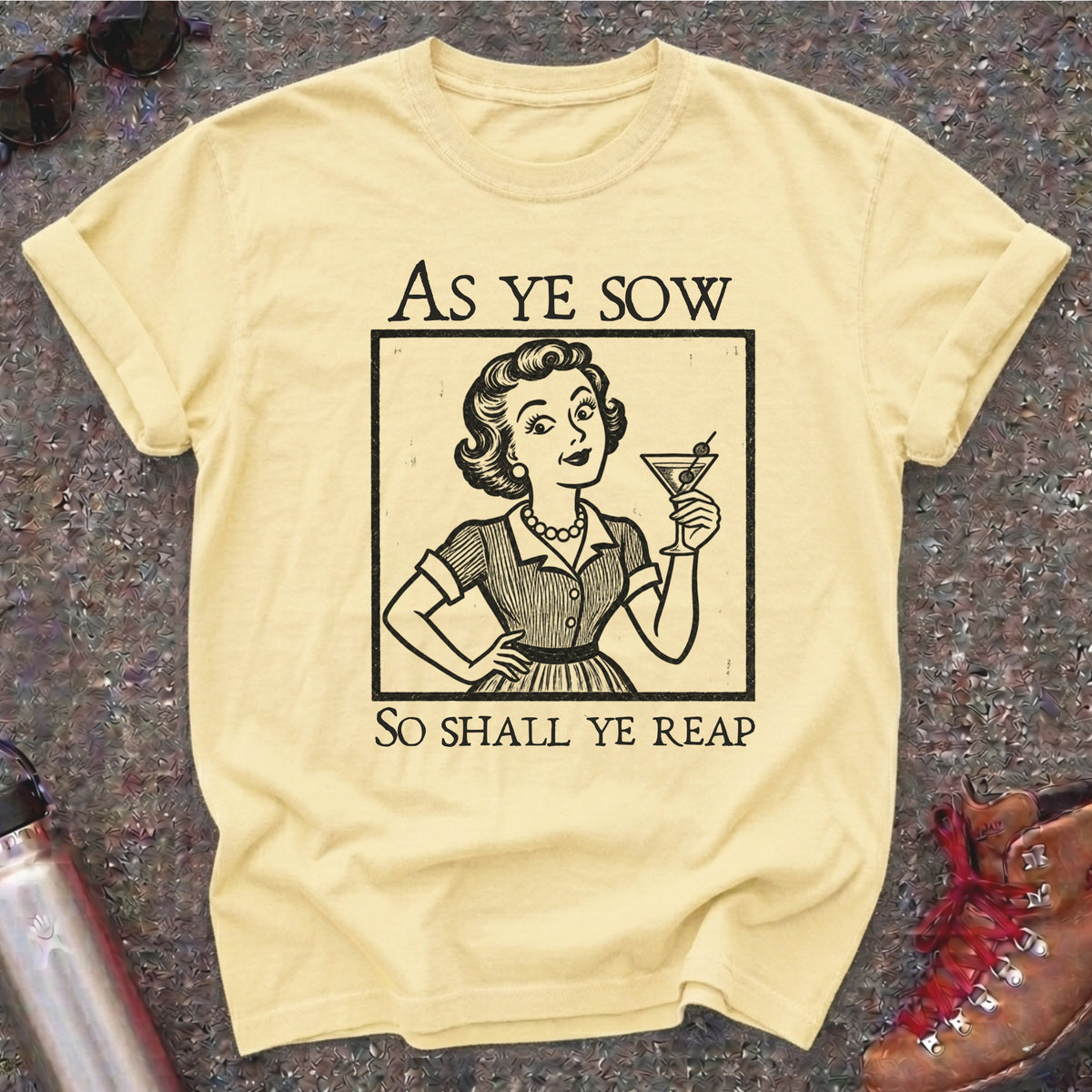 Comfort Colors t-shirt with a retro 1950s housewife raising a martini in vintage woodcut style and the words As Ye Sow So Shall Ye Reap