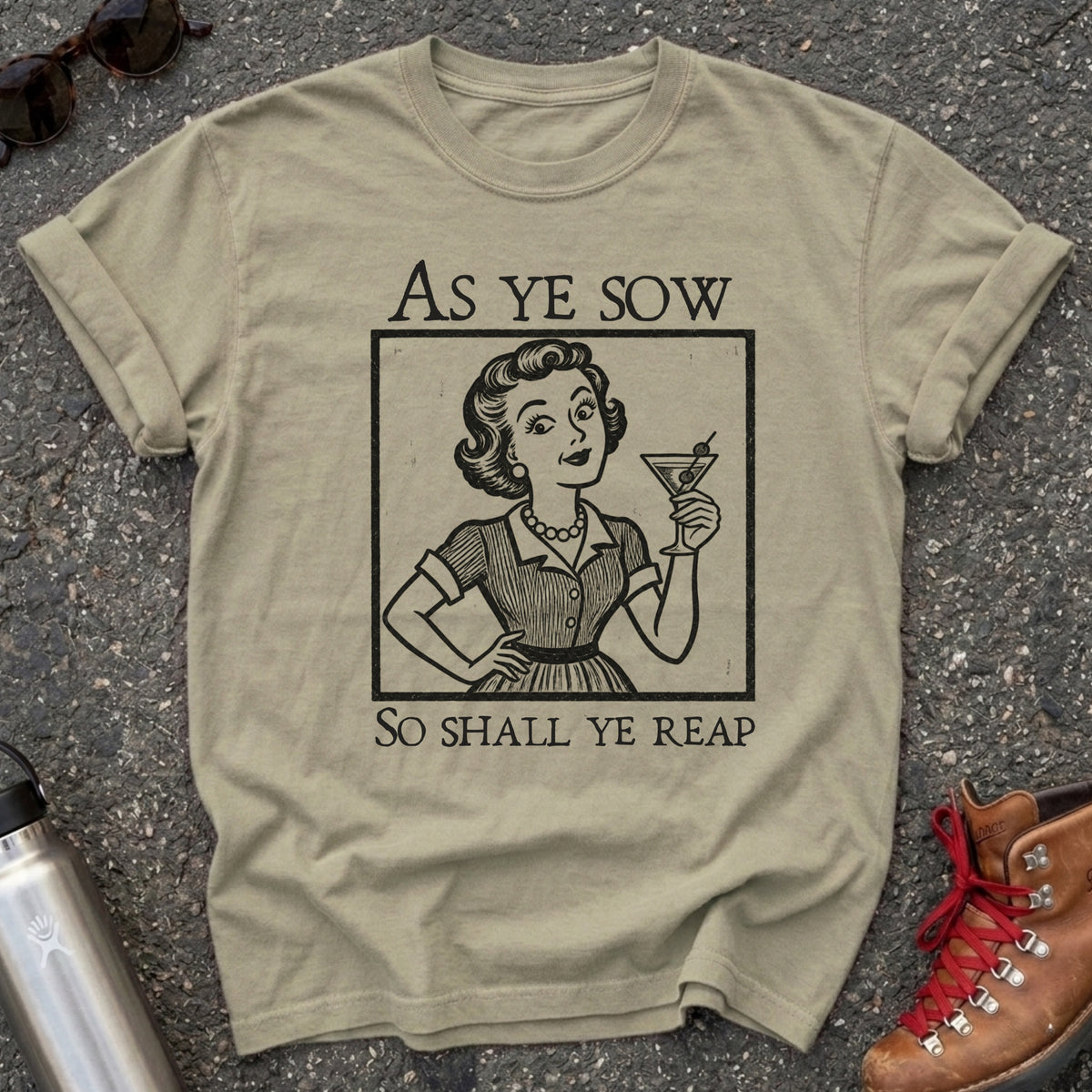 Comfort Colors t-shirt with a retro 1950s housewife raising a martini in vintage woodcut style and the words As Ye Sow So Shall Ye Reap
