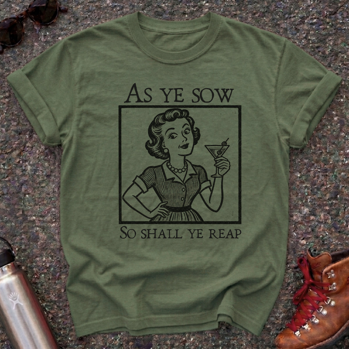 Comfort Colors t-shirt with a retro 1950s housewife raising a martini in vintage woodcut style and the words As Ye Sow So Shall Ye Reap