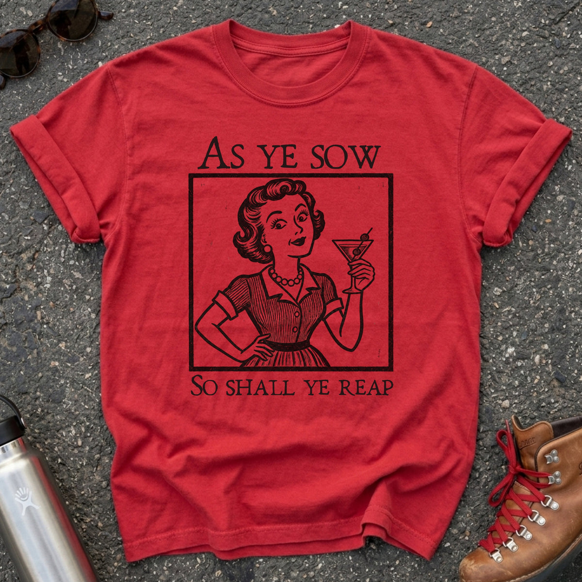 Comfort Colors t-shirt with a retro 1950s housewife raising a martini in vintage woodcut style and the words As Ye Sow So Shall Ye Reap